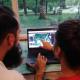 Two permaculture designers looking at permaculture design on a laptop screen.